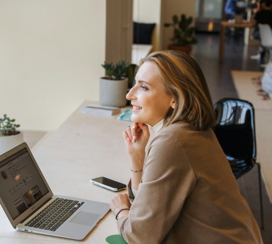 woman in brown coat using macbook air